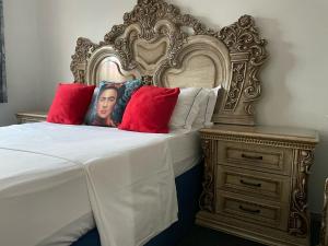 a bed with an ornate headboard next to a night stand at Afrite Rooms Goodwood in Cape Town