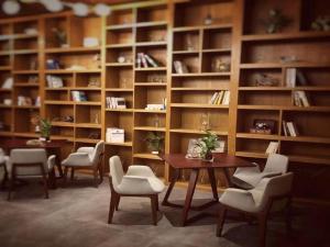 a room with a table and chairs and book shelves at James Joyce Coffetel·Anyang Text Museum in Anyang