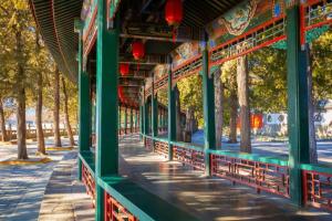 ein grünes Gebäude mit Bäumen und einem Bürgersteig in der Unterkunft James Joyce Coffetel·Renmin University Metro Station in Peking