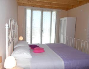 a bedroom with a bed with pillows and a large window at Porto Katsiki Blu in Athani