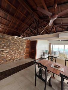 a dining room with a table and a stone wall at Blue Bay Beachfront 3 bedrooms Penthouse in Blue Bay