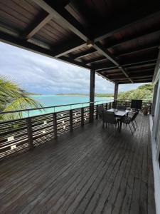 a deck with a table and chairs and the ocean at Blue Bay Beachfront 3 bedrooms Penthouse in Blue Bay