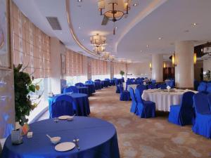 a large banquet hall with blue tables and chairs at YONG JING VILLA in Xuejiawan