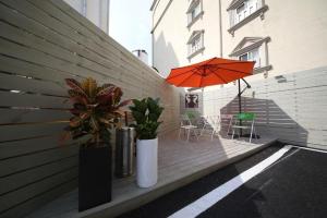 een patio met een oranje parasol en een tafel en stoelen bij Best In City Hotel in Daejeon