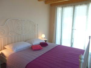 a bedroom with a large bed with purple sheets and pillows at Porto Katsiki Blu in Athani