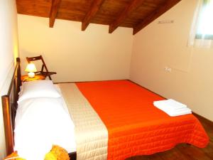 a bedroom with two beds with orange and white sheets at Porto Katsiki Blu in Athani