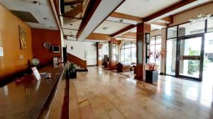 vestíbulo de un edificio con una habitación grande con ventanas en Samainiyom Hotel, en Sathani Phitsanulok