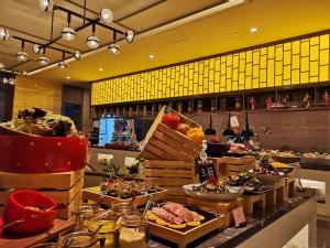 a buffet line with food on display in a restaurant at Landison Xinan Hotel Hangzhou in Jiande
