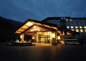 a building with a fountain in front of it at night at Landison Xinan Hotel Hangzhou in Thousand Island Lake