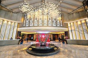 eine große Lobby mit einer großen Vase in der Mitte in der Unterkunft Landison Xinan Hotel Hangzhou in Jiande