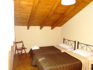 a bedroom with two beds and a wooden ceiling at Porto Katsiki Blu in Athani