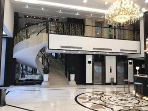 een grote lobby met een trap en een kroonluchter bij Xana Hotelle·Jinjiang Airport Yangguang Road Food court in Jinjiang