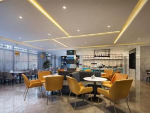 un restaurante con sillas y mesas en una habitación en Magnotel Hotel Liaocheng Development Zone Zhenhua Shopping Center, en Liaocheng