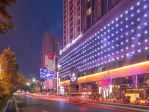 a city street at night with a building with lights at Magnotel Hotel Shiyan Wuyan Pedestrian Street in Shiyan