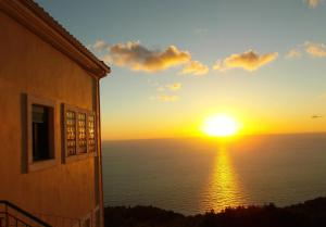 a sunset over the ocean from a building at Porto Katsiki Blu in Athani