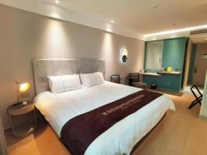 a bedroom with a large bed in a room at Magnotel Hotel Shiyan Wuyan Pedestrian Street in Shiyan