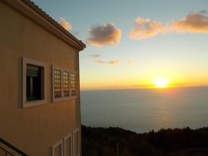 a sunset over the ocean from a building at Porto Katsiki Blu in Athani