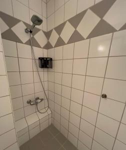 ein Bad mit einer Dusche mit einem Duschkopf in der Unterkunft Luxury Service Apartment by Chanya in Ålesund
