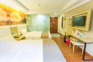 ein Hotelzimmer mit 2 Betten, einem Schreibtisch und einem TV in der Unterkunft PAI Hotel·Chongqing Jiangbei Airport Changfu Road Light Rail Station in Yubei