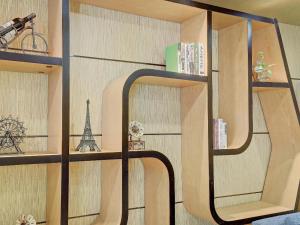 a room with a shelf with a reflection of the eiffel tower at Chonpines Hotel·Jining Railway Station Wanda Plaza in Jining