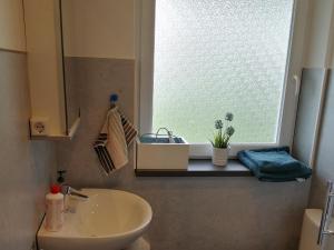 ein Bad mit einem Waschbecken und einem Fenster in der Unterkunft Ferienwohnung Gruberhörndlblick in Inzell