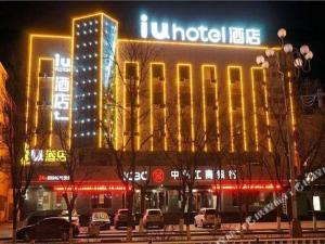 a building with neon lights in a city at night at IU Hotel·Jiayuguan People's Shopping Mall in Jiayuguan