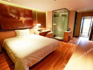 a bedroom with a large bed and a mirror at IU Hotel·Jiayuguan People's Shopping Mall in Jiayuguan