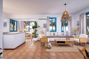 a living room with white furniture and blue windows at Blue Waves Villa by Nomads in Kissonerga