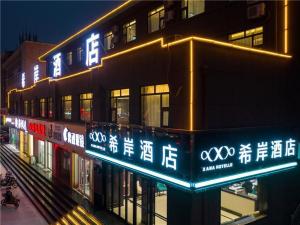 a building with neon signs on the side of it at Xana Hotelle·Zibo Shandong University of Technology East Campus in Zibo