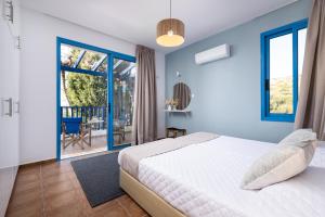 a bedroom with a bed and a balcony at Blue Waves Villa by Nomads in Kissonerga +18 photos