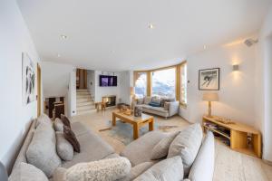 ein Wohnzimmer mit einem Sofa und einem Tisch in der Unterkunft Chalet Enchanteur in Nendaz