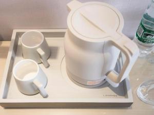 a white tea pot and two cups on a tray at Lavande Hotel·Tianmen Xincheng in Tianmen