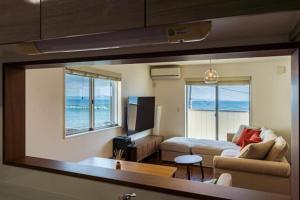 Oceanfront Villa Hale Kahakai - Vacation STAY 52334v في ميورا: غرفة معيشة مع أريكة وطاولة