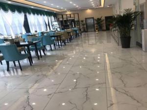 un restaurant avec un sol en marbre, des tables et des chaises dans l'établissement Xana Hotelle·Lianyungang Donghai, à Donghai