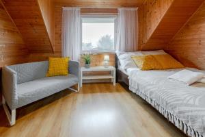 ヤストシェンビャ・グラにあるDOMKI LAURA z sauną i gorącą balią z jacuzziのベッド2台、椅子、窓が備わる客室です。