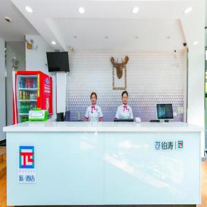dos personas parados en un mostrador en una tienda en PAI Hotel·Chengdu Jinsha Museum Metro Station en Chengdú