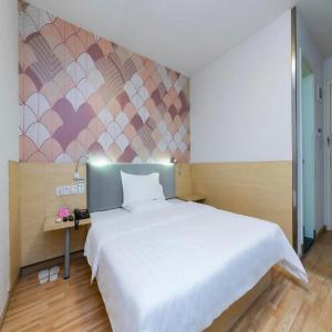 Un dormitorio con una gran cama blanca y una pared en PAI Hotel·Chengdu Jinsha Museum Metro Station en Chengdú