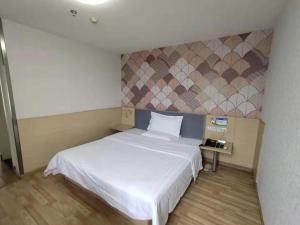 um quarto com uma cama branca e uma parede em PAI Hotel·Chengdu Jinsha Museum Metro Station em Chengdu
