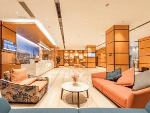 a lobby with two couches and a table at Chonpines Hotel Guangzhou Sunac Cultural and Tourism City Shiling in Huadu