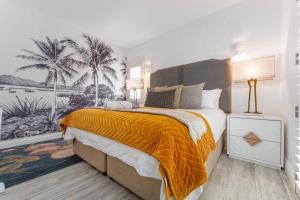 Un dormitorio con una cama grande con una manta naranja. en 4 Perissa- Luxury beach break, en Ballito