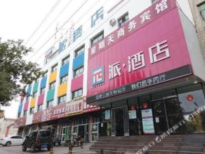 ein Gebäude mit farbigen Schildern an der Seite in der Unterkunft PAI Hotel·Hami Yingbin Avenue Airport in Hami