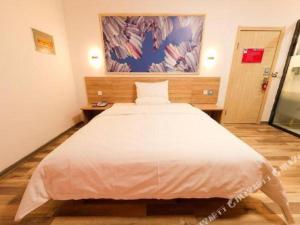 Schlafzimmer mit einem großen weißen Bett in der Unterkunft PAI Hotel·Hami Yingbin Avenue Airport in Hami