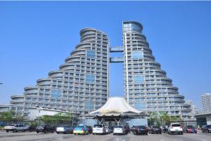 a large building with cars parked in a parking lot at Chonpines Hotel·Rizhao Yingbing Road RT-Mart in Rizhao