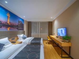 a hotel room with a large bed and a desk at Chonpines Hotel·Rizhao Yingbing Road RT-Mart in Rizhao