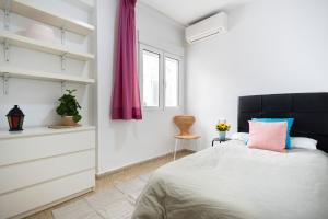 a bedroom with a bed and a dresser at Home San Jeronimo in Granada