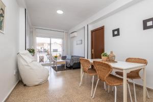sala de estar con mesa blanca y sillas en Home San Jeronimo, en Granada