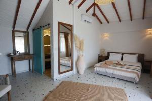 a bedroom with a bed and a large mirror at Glenn Hotel & Beach in Ayvacık