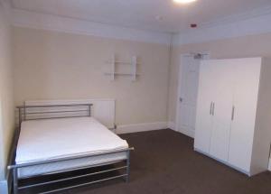 um quarto vazio com uma cama e um armário em Durley house em Alphington