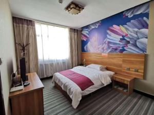 PAI Hotel Huayin Huashan Mountain Scenic Spot Ancient Street في Huayin: غرفة نوم بسرير جداري عليه ورد