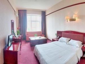 um quarto de hotel com uma cama grande e uma secretária em James Joyce Coffetel·Chadianzi Passenger Terminal Jinke Bei Road Metro Station em Supoqiao